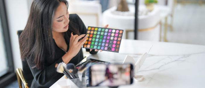 a beauty influencer demonstrating a colorful cosmetic palette on livestream