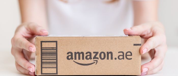a woman holding a box with the Amazon logo