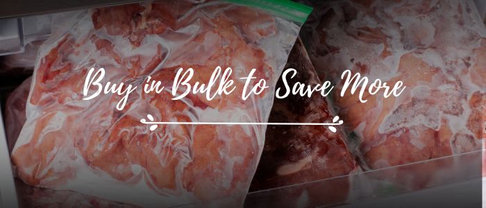 fh-inblog-freezer-bags-with-meat-portions (3) freezer bags filled with frozen meat portions layered in a freezer drawer with text buy in bulk to save more