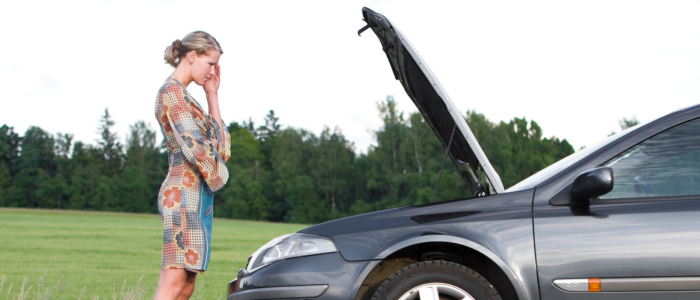 A woman standing beside a car with the hood open, looking stressed, representing an unexpected car repair expense