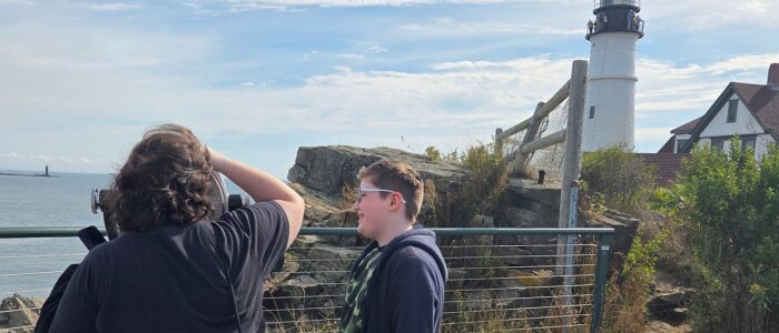 fh-inblog-kids-lighthouse-day Two kids looking out at a lighthouse by the ocean, representing simple, meaningful family experiences that don’t have to cost much.